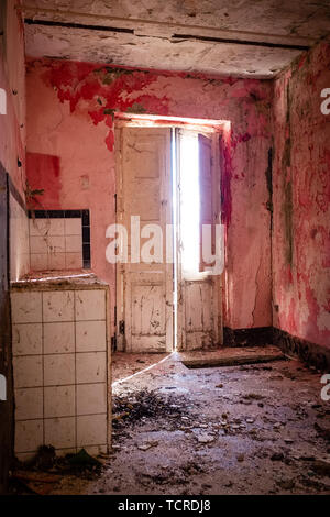 Stanza vuota con rosa pareti dipinte. Uno scorcio della città fantasma Alianello. Provincia di Matera, Italia Foto Stock