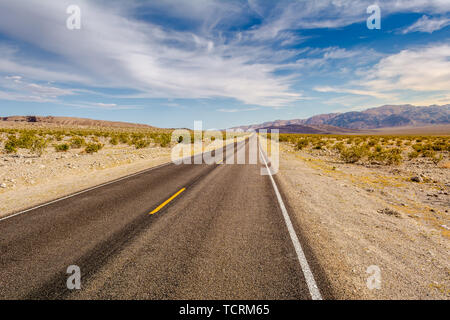 La strada attraverso un deserto e montagne in California, Stati Uniti d'America Foto Stock