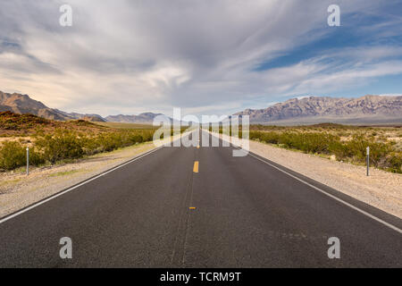 La strada attraverso un deserto e montagne in California, Stati Uniti d'America Foto Stock