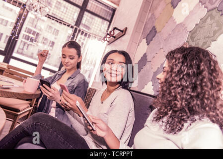 Tre belle dai capelli scuri aventi imprenditrici riunione informale sul weekend Foto Stock