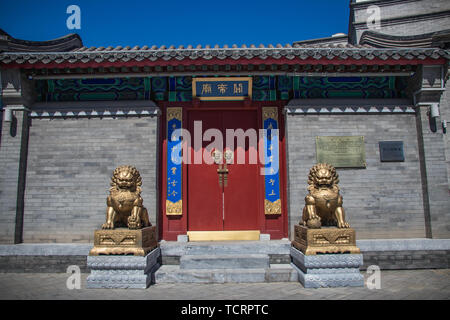 Wuwei metallo lion davanti al grande cancello rosso del tempio Guandi a Pechino Foto Stock