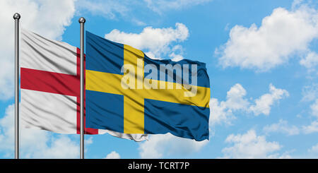 Inghilterra e Svezia bandiera sventolare nel vento contro bianco torbido cielo blu insieme. Concetto di Diplomazia e relazioni internazionali. Foto Stock