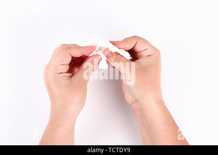 Salviette per la ragazza le mani con un bianco tovagliolo di carta su uno sfondo bianco. Vista dall'alto. Foto Stock