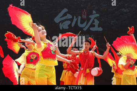 Zaozhuang, la Cina della provincia dello Shandong. Il 9 giugno, 2019. I partecipanti eseguono Lu 'nan Flower Drum danza al Taierzhuang antica città di Zaozhuang, est della Cina di Provincia di Shandong, 9 giugno 2019. Xuemei lunga è stata riconosciuta nel 2018 come l'erede di Lu 'nan fiore Danza del tamburo, una provinciale patrimonio culturale immateriale di Shandong. Non solo hanno lungo il tradizionale Lu 'nan Flower Drum Dance innervata, ma anche lei addestrato oltre duemila persone, alcuni dei quali sono di eseguire la danza per turisti alla Taierzhuang antica città. Credito: Sun Zhongzhe/Xinhua/Alamy Live News Foto Stock