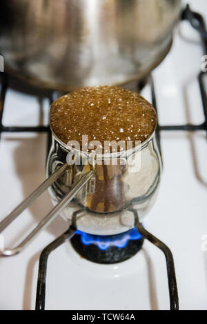 Il caffè turco pot ed il punto di ebollizione del caffè sul fornello a gas, bevande inebrianti. Foto Stock