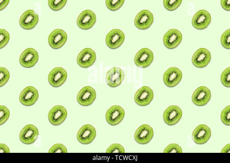 Fette di Kiwi seamless pattern pastello su sfondo verde. La minima nozione d'estate. Piatto, laici alla moda colore succosa. Foto Stock