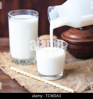 Versando in casa il kefir, yogurt con probiotici probiotico di freddo latticini fermentati bevanda alla moda di cibi e bevande spazio copia stile rustico Foto Stock