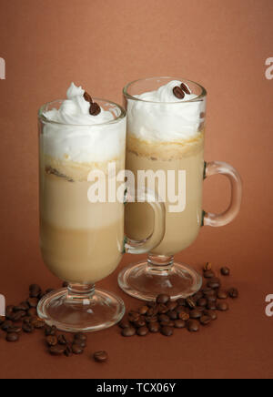 Fragranti caffè latte in bicchieri Tazze, su sfondo marrone Foto Stock