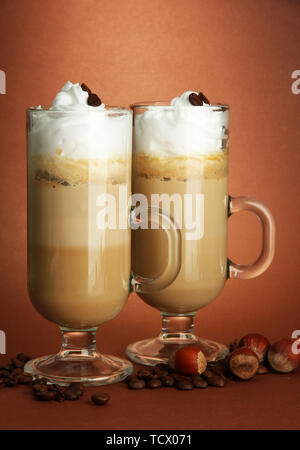 Fragranti caffè latte in bicchieri Tazze, su sfondo marrone Foto Stock