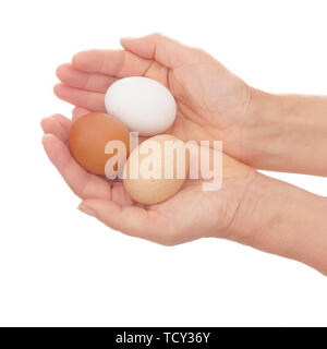 Le mani con tre diversi colori uova. Marrone, Bianco e colore speckeld. Isolato su bianco. Foto Stock