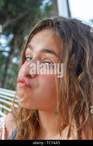 Cute girl teen contorce facce divertenti e rendendo le labbra di anatra Foto Stock