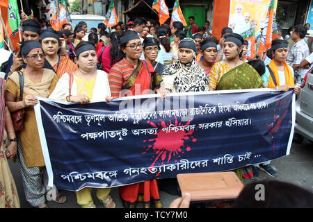 BJP MP medaglione Chatterjee detiene un banner lungo con BJP lavoratori femmina durante la protesta in Kolkata. Almeno quattro persone sono state uccise e altri tre gravemente feriti negli scontri scoppiati tra tutti India Trinamool Congress e Bhartiya Janata Party sostenitori in Area Basirhat in Nord 24 Parganas quartiere sulla notte di sabato. Si è affermato che gli scontri scoppiati oltre la rimozione di bandiere dei partiti politici. Membro BJP segretario generale Sayantan Basu detto, tre BJP parte lavoratori Sukanta Mondal, Pradip Mondal e Shankar Mondal morì in questo scontro. Foto Stock