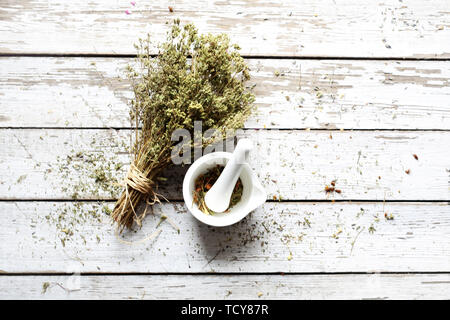 Composizione di erbe essiccate. Miscela aromatica grattugiato nella malta. Sfondo, composizione orizzontale con spazio per testo, vista dall'alto Foto Stock