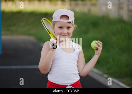 Felice bambina gioca tennis all'aperto Foto Stock