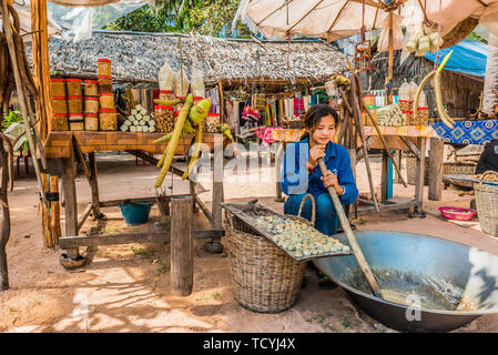 Angkor, Cambogia - Gennaio 2, 2014: ragazza la realizzazione e la vendita di canna da zucchero dolci a Angkor Cambogia in gennaio 2nd, 2014 Foto Stock