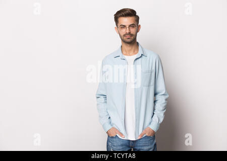 Grave la millenaria ragazzo indossa occhiali abbigliamento casual in posa studio shot Foto Stock