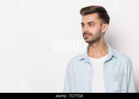 Bel ragazzo cerca oltre a copiare lo spazio bianco di sfondo per studio Foto Stock