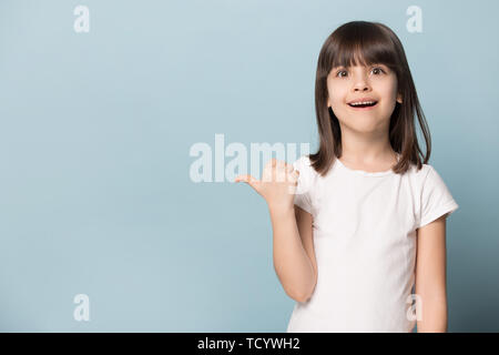 Storditi bambina guarda al punto della fotocamera sul dito copyspace Foto Stock