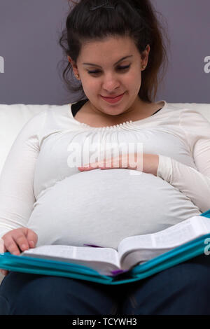 Giovani donne incinte mom a leggere la Bibbia al mattino Foto Stock