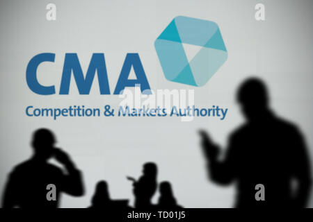 Il logo di CMA è visto su uno schermo a LED in background mentre si profila una persona utilizza uno smartphone in primo piano (solo uso editoriale) Foto Stock