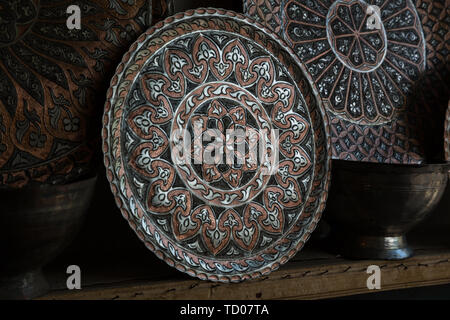 Piastra di rame artigianale, tradizionalmente realizzati in Lagich, Azerbaigian. Piastra a mano nel negozio di souvenir. Foto Stock