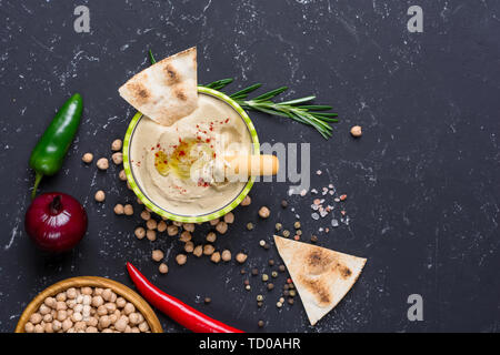 In casa hummus con pita e grissini peperoncino jalapeno, sulla pietra nera tabella. Medio Orientale tradizionale e autentica cucina araba. Parte superiore Foto Stock