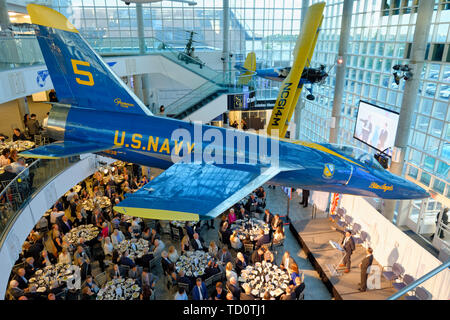 Città Giardino, New York, Stati Uniti d'America. Il 6 giugno, 2019. Sul palco (all ambone) MICHAEL STROMER, JetBlue Chief Product Officer di tecnologia; e MARC MACDONNELL, Presidente del Consiglio di Amministrazione di base di aviazione, come si vede dal terzo livello di atrio della camma, durante Apollo a 50 Anniversario Cena, un astronauta Apollo omaggio celebra la missione Apollo 11 sbarco sulla Luna. Stati Uniti Navy Blue Angels Grumman F-11A Tiger jet è sospesa dal soffitto. Credito: Ann Parry/ZUMA filo/Alamy Live News Foto Stock