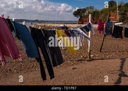 Linee di multi abbigliamento colorato che sono state lavate e appesa ad asciugare in ambiente insolito di un fiume mentre la marea è fuori sull'estuario del fiume, Nessuno nell'immagine Foto Stock