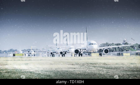 Aerei di linea sulla pista in Blizzard. Aeromobili durante il rullaggio a neve pesante. Piano di passeggeri nella neve in aeroporto Foto Stock