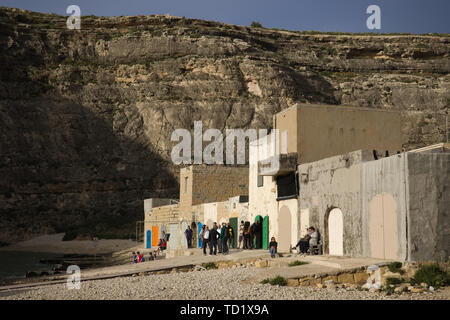 Isola di Gozo, Malta - Maggio 2019: gruppo di persone in attesa sul molo di mare interno (punto di immersione) a guardare attraverso l'apertura nella roccia. Foto Stock