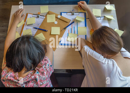 Vista dall'alto di esaurito donne dormire sul posto di lavoro Foto Stock