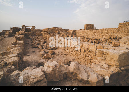 Le rovine della fortezza di Masada, Israele. Vista di età compresa tra i suoi edifici in pietra costruito sulla montagna plateua. Costruzione in pietra contro il cielo. Archeologia. Resti di Foto Stock