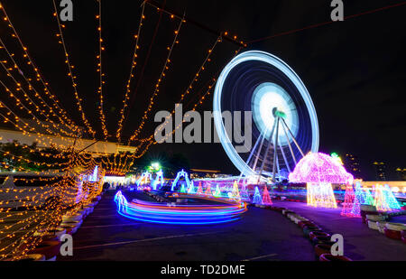 Blur ruotare lo spostamento della ruota panoramica Ferris con illuminazione al parco di carnevale in tempo di notte Foto Stock