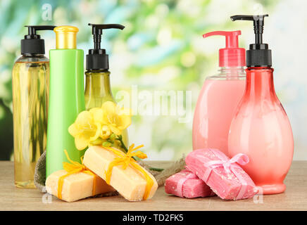 Liquido e fatti a mano Saponi sul tavolo di legno, su sfondo verde Foto Stock