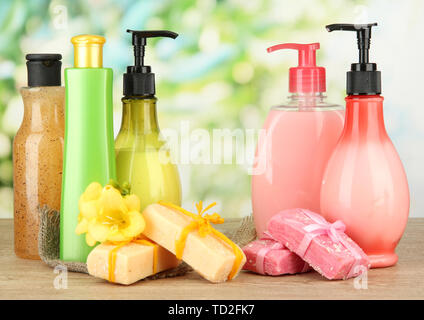 Liquido e fatti a mano Saponi sul tavolo di legno, su sfondo verde Foto Stock