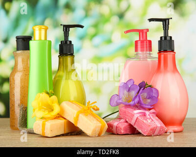 Liquido e fatti a mano Saponi sul tavolo di legno, su sfondo verde Foto Stock