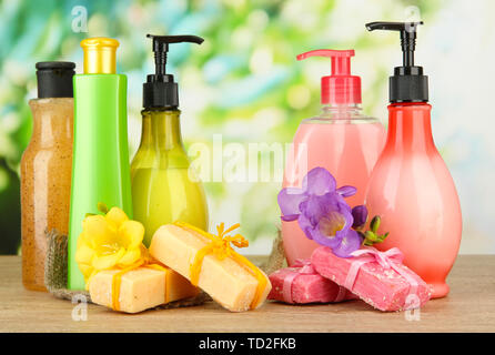 Liquido e fatti a mano Saponi sul tavolo di legno, su sfondo verde Foto Stock