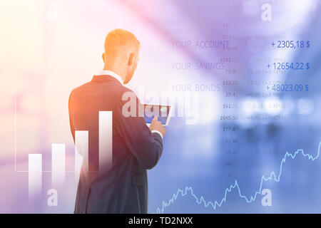 Giovane uomo che controlla il suo portafoglio di investimenti sul suo computer tablet, online trading concetto, doppia esposizione Foto Stock