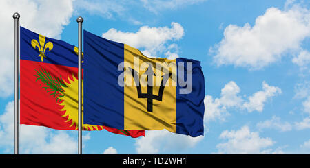 La Guadalupa e Barbados bandiera sventolare nel vento contro bianco torbido cielo blu insieme. Concetto di Diplomazia e relazioni internazionali. Foto Stock