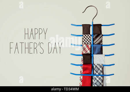 Il testo happy padri di giorno e una cravatta appendiabiti con alcune cravatte di diversi colori e disegni, su un fondo bianco Foto Stock