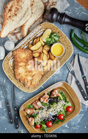 Concetto di cibo, tavolo con vari snack collocato su di esso. Insalata con salmone, Cesare skuric, funghi sott'aceto, pane. Foto Stock