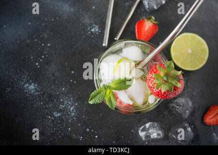 Detox acqua o mojito con calce, fragola in vetro. Estate una sana freschezza bere. Close up. Foto Stock