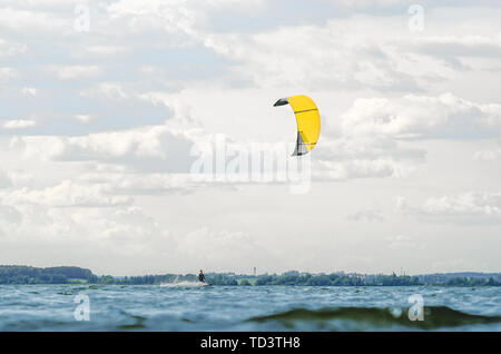 Un kiteboarder viene tirato attraverso l'acqua da un aquilone di potenza Foto Stock