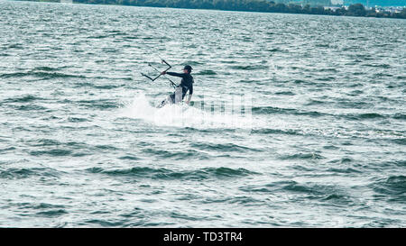 Un kiteboarder viene tirato attraverso l'acqua da un aquilone di potenza Foto Stock