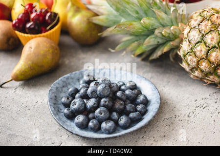Organici di mirtilli e frutta fresca. Dieta vegetariana e mangiare sano concetto. Foto Stock