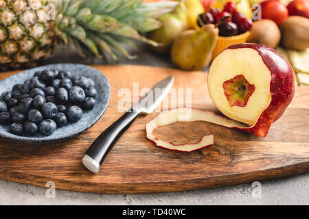 La preparazione di freschi colorati misti insalata di frutta su legno tagliere. La dieta e il mangiare sano concetto. Foto Stock