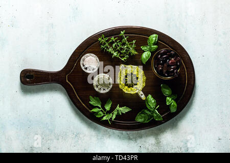 Erbe aromatiche per la cottura e olio di oliva su una tavola di legno sul tavolo. ingredienti in cucina Foto Stock