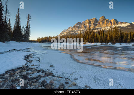 Tramonto al castello di montagna con congelato il Fiume Bow in inverno, il Parco Nazionale di Banff, Sito Patrimonio Mondiale dell'UNESCO, Alberta, Canadian Rockies, Canada, a nord di un Foto Stock