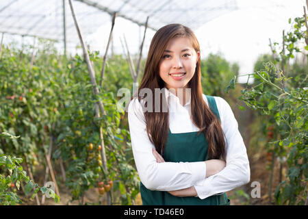 Giovane bella donna asiatica lavora nel campo verde Foto Stock