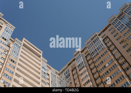 Alto edificio ad angolo. alto edificio in mattoni residenziale complesso. Alloggiamento per famiglie. Nuovo multi-piani casa beige con un sacco di windows. Foto Stock